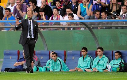 Guardiola pide calma a sus jugadores mientras los suplentes observan el partido detrás.
