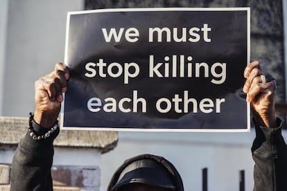 "Debemos dejar de matarnos unos a otros", reza una pancarta en una protesta contra la violencia de armas.