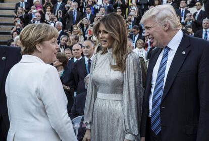 El presidente de los Estados Unidos, Donald Trump (d), y a la primera dama, Melania Trump (c), mientras conversan con la canciller alemana, Angela Merkel (i), a su llegada a un concierto en el teatro griego en el ámbito de la cumbre de líderes del G7 en Taormina (Italia).