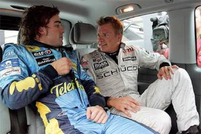 Fernando Alonso y Kimi Raikkonen conversan en la furgoneta que les condujo al podio tras la carrera.
