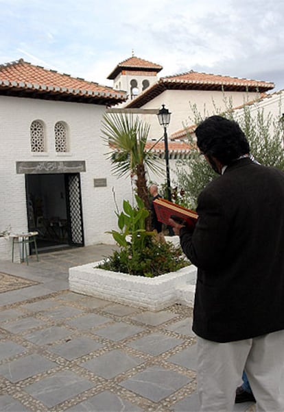 Un musulman en el jardín de la mezquita Mayor de Granada con un Corán en las manos.