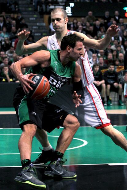 Carl English protege el balón ante el acoso de Andrés Miso.