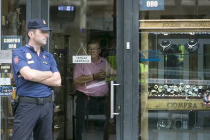 Un agent dels Mossos a la porta de la joieria.