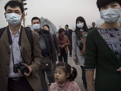 Varias personas con mascarillas en la plaza de Tiananmen de Pek&iacute;n. 