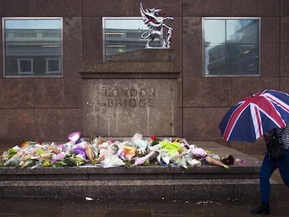 Mulher passa em frente aos ramos de flores deixados em homenagem às vítimas do atentado do sábado na London Bridge.