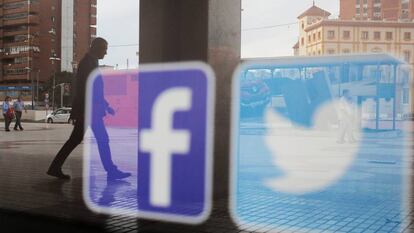Los logos de las redes sociales Facebook y Twitter aparecen en el escaparate de una tienda en Málaga.
