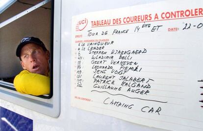 Lance Armstrong looks from the window of a doping control van during the 2001 Tour de France. 