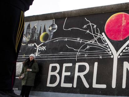 BERLIN, GERMANY - FEBRUARY 05: Vsitor passing a painting at the Berlin Wall at the East Side Gallery on February 5, 2018 in Berlin, Germany. Today tem been 10,316 days since the Berlin Wall officially fell, the same number of days that it stood between 1961 and 1989. The Berlin Wall, built by the communist authorities of East Germany, divided capitalist West Berlin from communist East Berlin and came to symbolize the Cold War between the western Allies, led by the United States, and the Eastern Bloc, led by the Soviet Union. (Photo by Carsten Koall/Getty Images)