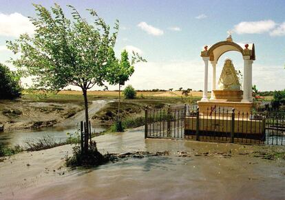 Un altar con la imagen de la Virgen del Rocío aparece rodeada de agua y barro tóxico, después de la rotura de una presa que contenía agua tóxica, en Aznalcóllar, el 26 de abril de 1998.