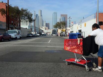 Uma mulher sem teto caminha pelas ruas do centro de Los Angeles.