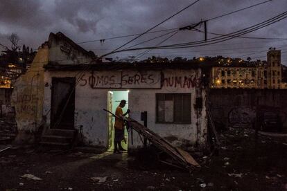 Un hombre en la puerta de una casa ocupada en la favela Vila do Metrô, Mangueira, Río de Janeiro, Brasil. El grafiti pintado en la casa dice “Somos seres humanos”.La favela de Mangueira se encuentra a tan solo un kilómetro del estadio de Maracaná. No obstante, centenares de familias siguen viviendo en alojamientos improvisados o en edificios abandonados sin instalaciones sanitarias, agua corriente ni seguridad.