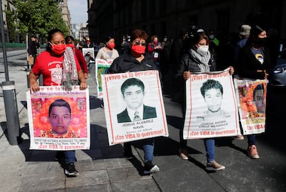 La madre de Christian Rodríguez, uno de los 43 estudiantes desaparecidos de Ayotzinapa, sostiene un cartel fuera del Palacio Nacional de México.