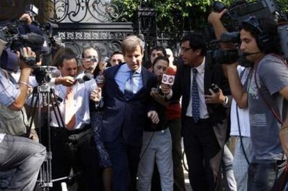 Redrado se abre paso entre los periodistas que le esperaban el domingo ante su casa en Buenos Aires.