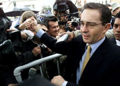 Álvaro Uribe saluda a sus partidarios tras depositar su voto en Bogotá.