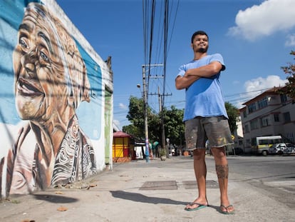 Wallace Pato, diante de uma pintura que fez em Ramos, no Rio.