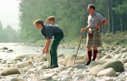 Agosto 1997. El príncipe de Gales (d) y sus dos hijos, William (i) y Harry, disfrutan de unos días de vacaciones en su castillo de Balmoral; en la foto los príncipes jugando con su perro terrier junto al río Dee.