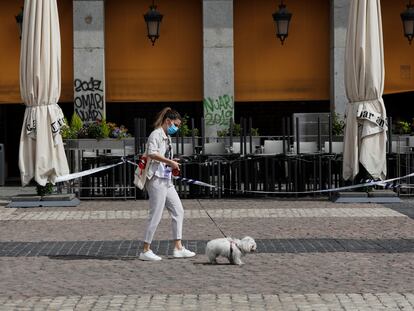 Una mujer protegida con mascarilla camina este sábado por la Plaza Mayor de Madrid.