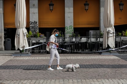 Una mujer protegida con mascarilla camina este sábado por la Plaza Mayor de Madrid.