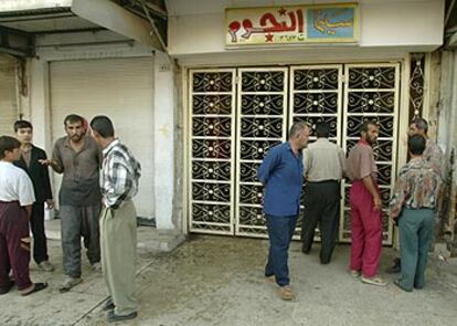 Varios hombres conversan junto al cine Al Nijum, en Mosul, donde una granada mató ayer a dos espectadores.