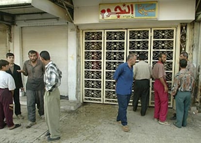 Varios hombres conversan junto al cine Al Nijum, en Mosul, donde una granada mató ayer a dos espectadores.