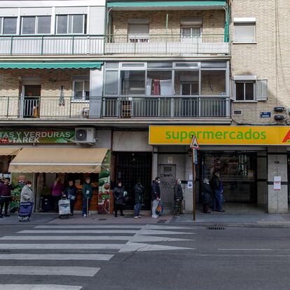 Varias personas con mascarilla hacen cola en un supermercado Ahorra Más a primera hora de la mañana respetando la distancia de seguridad aconsejada para no contraer el coronavirus durante el primer día laborable desde que se decretó el estado de alarma en todo el territorio nacional a consecuencia del COVI-19, en Alcorcón (Madrid), este lunes.