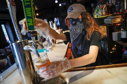 Una camarera sirve una cerveza en un bar de Nueva York, el pasado junio.
