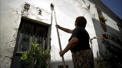 Manuela Delgado, vecina del pueblo gaditano de Medina Sidonia, encala la fachada de su casa en una imagen de archivo.