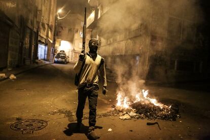 Un militante kurdo camina en el districto de Okmeydani de Estambul durante una manifestaci&oacute;n contra los &uacute;ltimos toques de queda impuestos en ciudades kurdas.