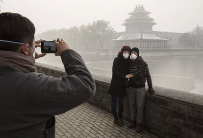 Los turistas que visitan la Ciudad Prohibida de Pekín utilizan máscaras para protegerse de la contaminación.