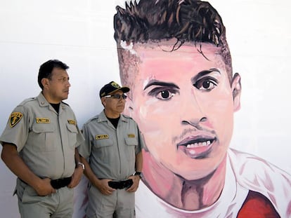 Dos policías delante de un grafiti con el rostro del futbolista Paolo Guerrero, una de las estrellas de la selección de Perú.
