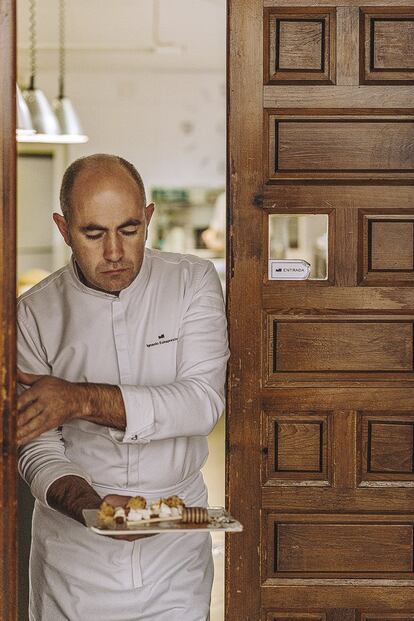 El chef con el postre queso, miel y nueces partidas.