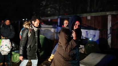 Una mujer con un niño y otras personas migrantes son desalojados por la policía de un asentamiento informal en La Porte d'Aubervilliers en Paris, Francia, en enero de 2020.