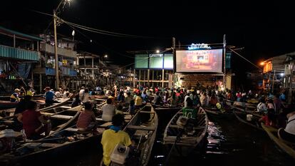 Habitantes de Iquitos (Perú) ven una proyección del festival de cine desde sus canoas y balcones.