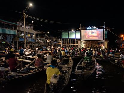 Habitantes de Iquitos (Perú) ven una proyección del festival de cine desde sus canoas y balcones.