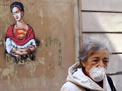 Una mujer con una mascarilla camina por el distrito judío en el centro de Roma el 24 de marzo de 2020.