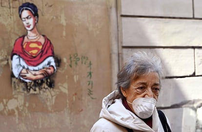 Una mujer con una mascarilla camina por el distrito judío en el centro de Roma el 24 de marzo de 2020.