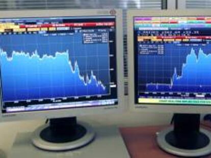 La pantalla refleja la evolución en la jornada de ayer de la prima de riesgo española (d), que cerró en 563 puntos básicos.
