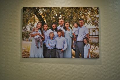 Ihor, junto a su mujer, Dana, y sus nueve hijos, en una foto que cuelga en el salón de su casa.