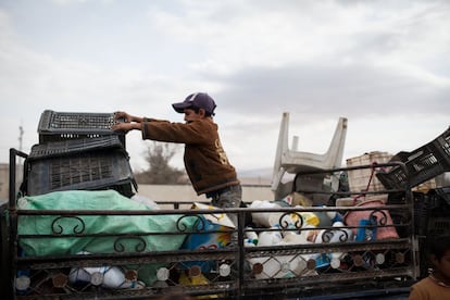 Un niño apila los desechos en el carro.