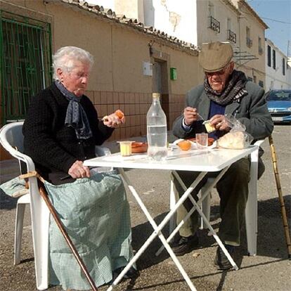 Un matrimono come en la calle junto a su vivienda, dañada por el seísmo, en la pedanía de Zarcilla de Ramos.