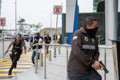 Policías persiguen a un presunto delincuente a pocas cuadras de la sede del canal de televisión TC en Guayaquil, este martes.