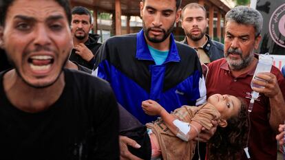Un palestino con una niña herida en brazos, después de que el Hospital Europeo de la Franja fuera bombardeado el martes por la noche, en Jan Yunis, Gaza.
