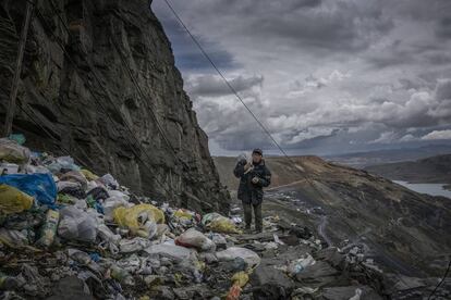 Un minero vuelve a casa caminando por un precipicio inundado por basura compuesta por plástico de un solo uso. La Rinconada, Perú.