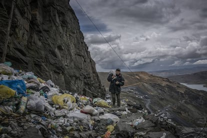 Un minero vuelve a casa caminando por un precipicio inundado por basura compuesta por plástico de un solo uso. La Rinconada, Perú.