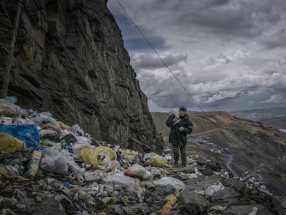 Un minero vuelve a casa caminando por un precipicio inundado por basura compuesta por plástico de un solo uso. La Rinconada, Perú.