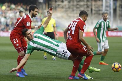 Alex Alegría, cae al suelo presionado por los defensas argentinos del Sevilla Nico Pareja y Gabriel Mercado.