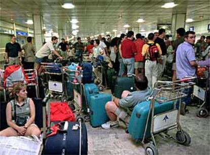 Pasajeros del vuelo chárter con destino a Cancún y Punta Cana esperan explicaciones en el aeropuerto de Barajas.