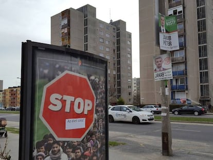 Una familia pasea junto a un cartel de la campaña estatal contra la inmigración, en Miskolc (Hungría), este miércoles.