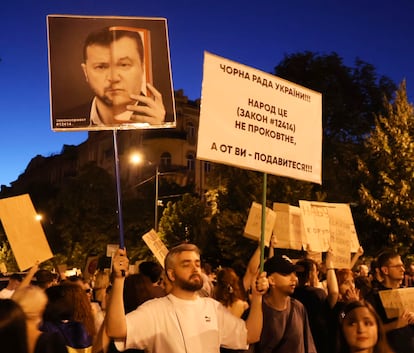 Un manifestante en Kiev muestra una fotografía en la que compara a Zelenski con el expresidente prorruso Víktor Yanukovich