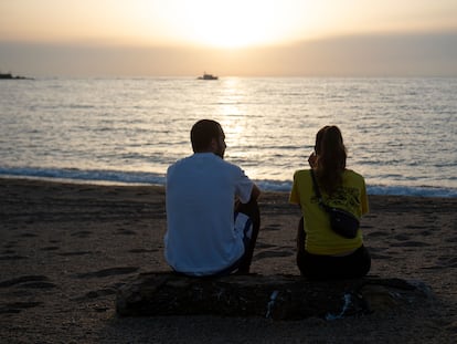 Una pareja observa el mar en una playa de Barcelona.